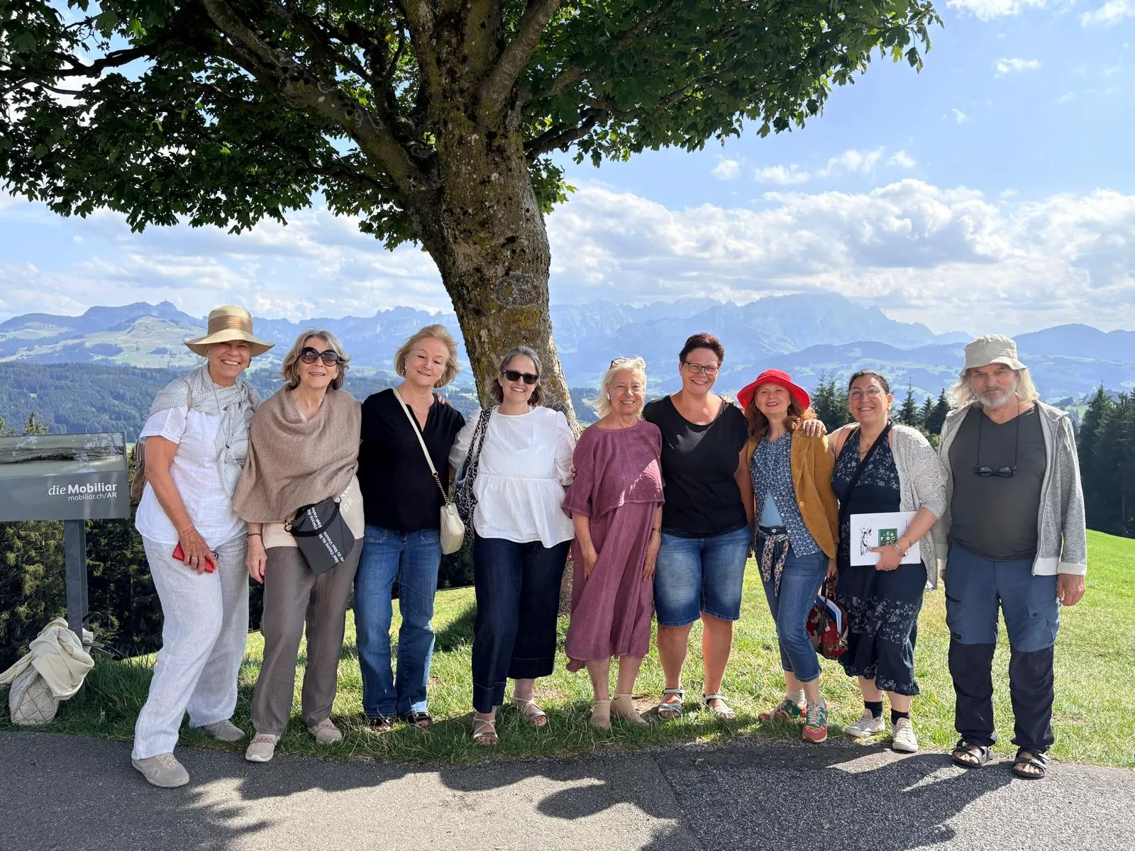 Le groupe sous un grand arbre, face aux montagnes d'Appenzell.